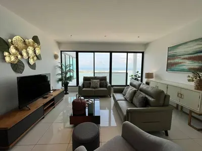 a living room with a couch and a television at Seaview Premium Duplex in Gurney with WiFi & Full Kitchen 12B in George Town
