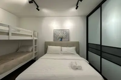 a bedroom with a bed and two bunk beds at Seaview Premium Duplex in Gurney with WiFi & Full Kitchen 12B in George Town