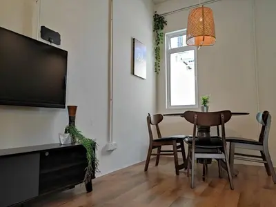 a living room with a table and chairs and a television at Heritage House 2BR in Town walkto UNESCO Site & StreetArt 45 in George Town