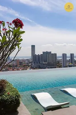 a swimming pool with two lounge chairs and a city at Seaview 2BR Infinity Pool & EasyAccess to Town 191 in George Town