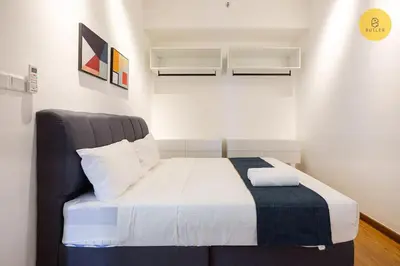 a bedroom with a bed with white sheets and blue blanket at Seaview 2BR Infinity Pool & EasyAccess to Town 201 in George Town