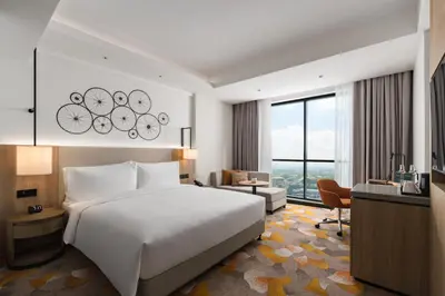 a bedroom with a large white bed and a desk at Holiday Inn & Suites Penang Prai by IHG in Bukit Mertajam