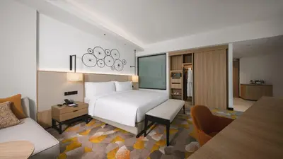 a hotel room with a bed and a kitchen at Holiday Inn & Suites Penang Prai by IHG in Bukit Mertajam