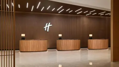 a lobby with a row of desks in a building at Holiday Inn & Suites Penang Prai by IHG in Bukit Mertajam