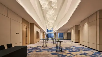 a long hallway with tables and chairs in a building at Holiday Inn & Suites Penang Prai by IHG in Bukit Mertajam