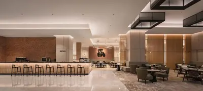 a lobby with a restaurant with tables and chairs at Holiday Inn & Suites Penang Prai by IHG in Bukit Mertajam
