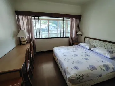 a bedroom with a bed and a desk and a window at The Family Hideaway 2 Bedroom Apartment at Equatorial Hill Resort in Brinchang