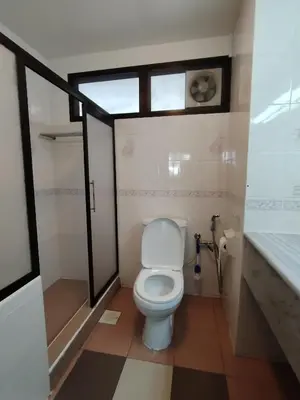 a bathroom with a toilet and a shower and a window at The Family Hideaway 2 Bedroom Apartment at Equatorial Hill Resort in Brinchang