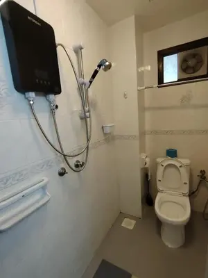 a bathroom with a shower and a toilet with a monitor at The Family Hideaway 2 Bedroom Apartment at Equatorial Hill Resort in Brinchang