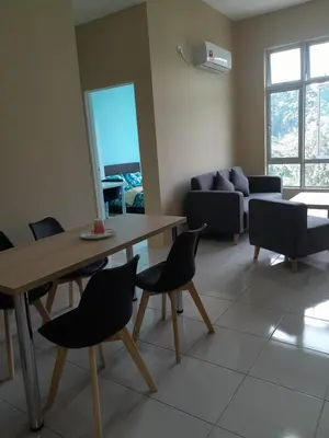 a living room with a table and chairs and a couch at The Anderson Condo with NETFLIX with Free Parking with Swimming Pool and at Ipoh City Centre Nearby to all amenities and attractions in Ipoh