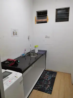 a small kitchen with a sink and a stove at Sunny Point Hostel in Gelugor