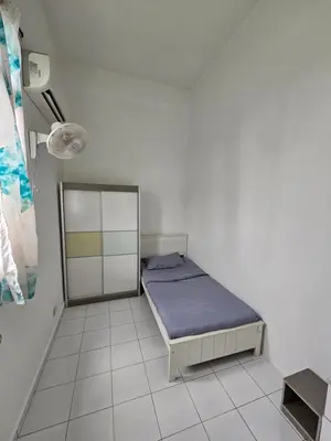 a bedroom with a bed in a white room at Sunny Point Hostel in Gelugor