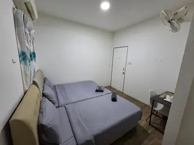 a small bedroom with a bed and a desk at Sunny Point Hostel in Gelugor
