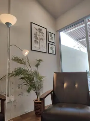 a living room with a chair and a plant at Heritage House 4BR with Dipping Pool, Central Location Near Street Art 45 in George Town