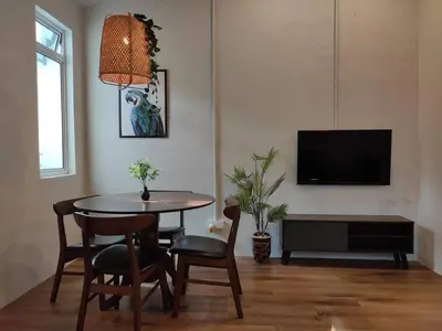 a living room with a table and chairs and a tv at Heritage House 5BR with Dipping Pool, Central Location Near Street Art 47 in George Town