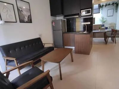 a living room with a black couch and a kitchen at Heritage House 5BR with Dipping Pool, Central Location Near Street Art 47 in George Town