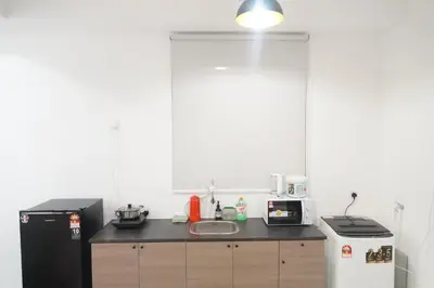 a kitchen with a black refrigerator and a sink at Urban Suites Infinity Pool 3BR 2Carparks 8pax in Jelutong