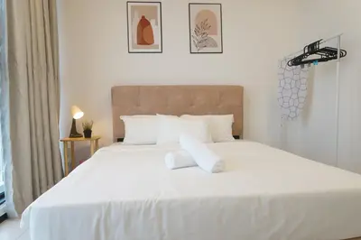 a white bed with two pillows on top of it at Urban Suites Infinity Pool 3BR 2Carparks 8pax in Jelutong