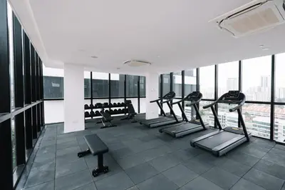 a gym with rows of tread machines and windows at Urban Suites Infinity Pool 3BR 2Carparks 8pax in Jelutong