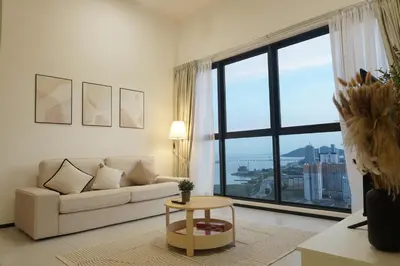a living room with a couch and a large window at Urban Suites Seaview 3Bedrooms 2Carparks 8pax in Jelutong