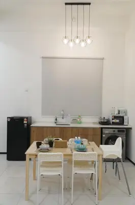 a kitchen with a wooden table and chairs in a kitchen at Urban Suites Seaview 3Bedrooms 2Carparks 8pax in Jelutong
