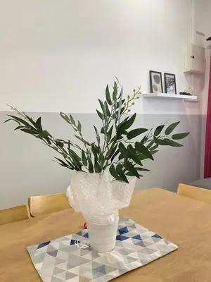 a plant in a white vase sitting on a table at Cozy Roomstay Teluk Intan in Teluk Intan