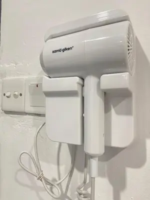 a hair dryer is attached to a wall at Cozy Roomstay Teluk Intan in Teluk Intan