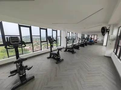 a gym with a row of treadmills and exercise bikes at Decozy 9 Ipoh Town Condo 12pax in Ipoh
