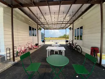 a patio with a table and chairs and bikes at IDAMAN COTTAGE Sekinchan in Tanjung Karang