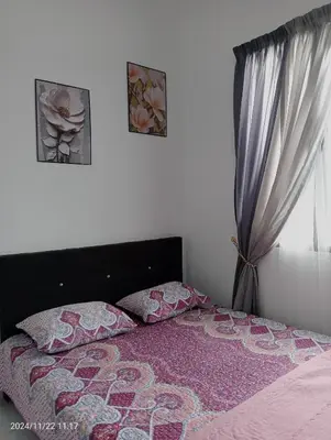 a bedroom with a bed and a window at Nana Homestay in Parit Buntar