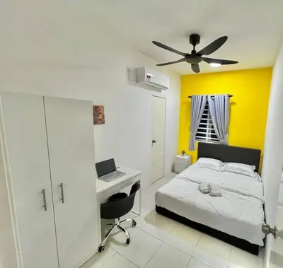 a bedroom with a bed and a desk with a laptop at Ipoh Anderson Cozy downtown in Ipoh