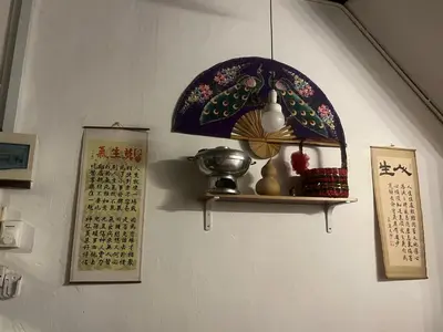 a wall with a shelf with a lamp and a calendar at EastOriental House in George Town