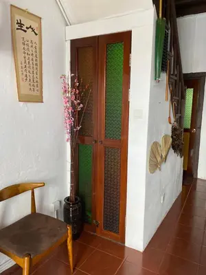 a room with a door and a chair and a plant at EastOriental House in George Town