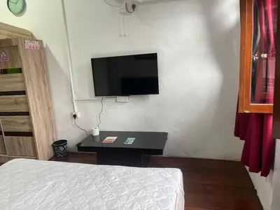 a bedroom with a bed and a tv on a wall at EastOriental House in George Town