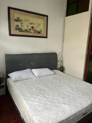 a bed in a bedroom with a white bedsheet at EastOriental House in George Town