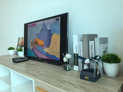 a flat screen tv sitting on a counter with books at Platinum Suite Meritus by Moowin in Perai