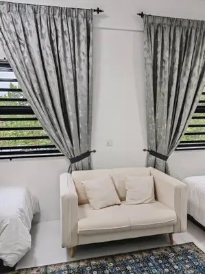 a living room with a couch in front of a window at Comfortable Greenery in Seri Iskandar