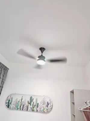 a ceiling fan hanging on a white wall at Comfortable Greenery in Seri Iskandar