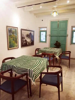 a room with tables and chairs and a green door at The Georgetown Green Gates in George Town