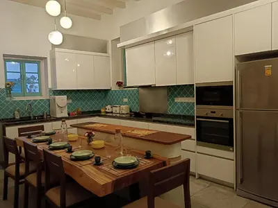a kitchen with a table with chairs and a refrigerator at The Georgetown Green Gates in George Town
