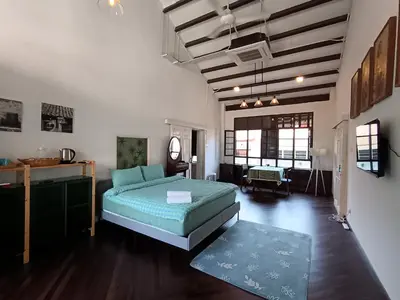 a bedroom with a bed and a room with a table at The Georgetown Green Gates in George Town