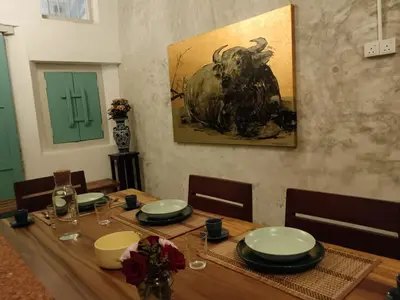 a dining room table with a picture of a bull on the wall at The Georgetown Green Gates in George Town