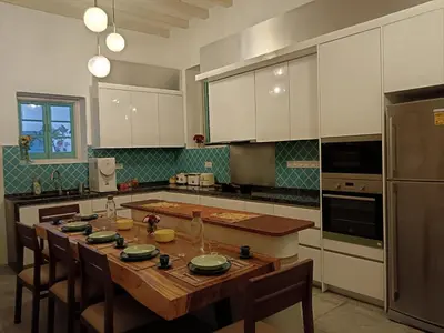 a kitchen with a wooden table with chairs and appliances at The Georgetown Green Gates in George Town