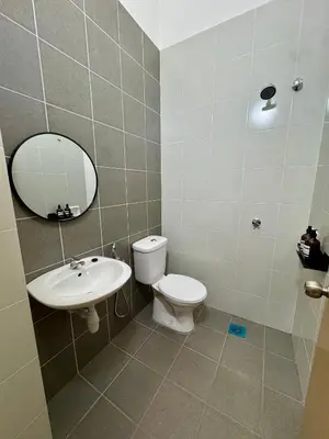 a bathroom with a toilet and a sink and a mirror at Rimbayu 81 in Kampung Bota Kiri