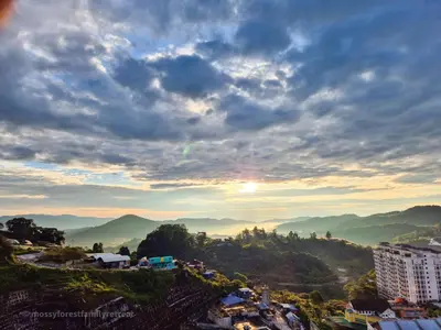 a view of a city with the sun setting over mountains at Mossy Forest Family Retreat III, 2-8pax, Sunrise View, Cameron Highlands in Cameron Highlands