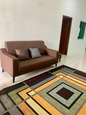 a brown couch in a living room with a rug at Impiana Inn Seri Manjung in Seri Manjung