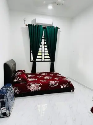 a bedroom with a bed and a window with green curtains at Homestay Nurwan in Bukit Mertajam