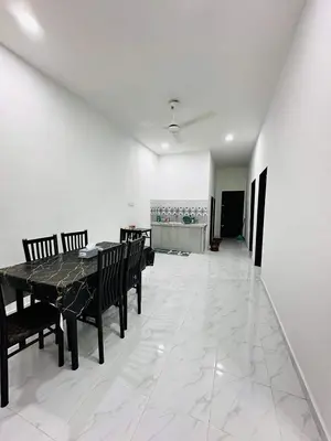 a dining room with a table and benches on a tile floor at Homestay Nurwan in Bukit Mertajam