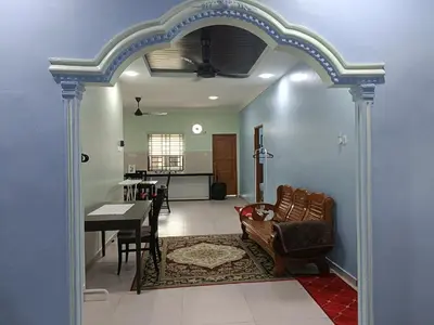 a living room with a table and a dining room at NHR Harmoni in Simpang Ampat