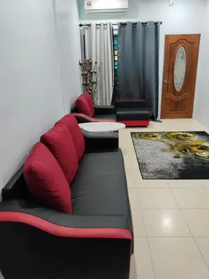 a living room with red pillows on a couch at Homestay Lyn Impian in Tanjung Rambutan